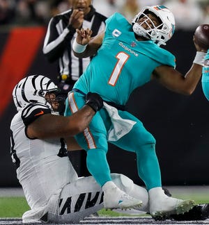 Bengals DT Josh Tupou (68) sacks Dolphins QB Tua Tagovailoa, leaving him concussed and sending the third-year passer to a local hospital.