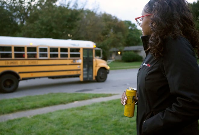 Shillam Daniels waits with her daughters Aaliyah, 13, and Amour, 9, for their school bus on Oct. 4, 2022 outside their apartment in Columbus' North Side.  The girls go to Graham Elementary and Middle School, a K-8 public charter school. First the bus didn't come, then once they did start getting a morning bus it stopped coming altogether. Charter schools rely on Columbus City Schools to provide bus transportation.