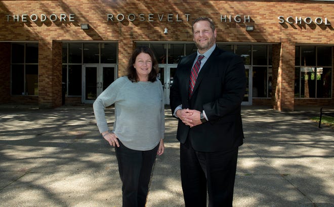 A new Kent City School District program, called Neighborhood Bridges, confidentially pairs up students and their families in need with donors willing to supply those needs. Pictured are Kathleen Wiler, the program's area director, and Justin Gavin, district director of student services, outside Theodore Roosevelt High School.