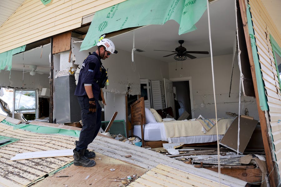 FORT MYERS BEACH, FLORIDA - OCTOBER 0:  A member of the City of Miami Florida Task Force 2 Search and Rescue team checks homes for victims in the wake of Hurricane Ian on October 3, 2022 in Fort Myers Beach, Florida.