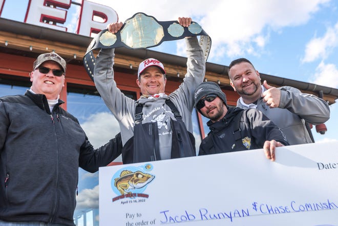 Jacob Runyan holds up a trophy belt alongside Chase Cominsky, second from right, after winning a fishing tournament in April in Rossford, Ohio. The two were disqualified from a Lake Erie Walleye Trail event last week amid accusations of cheating that have rocked the competitive fishing community.