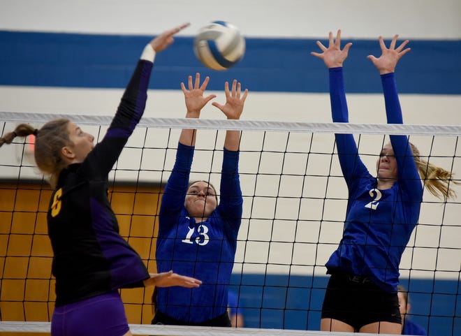 Sarah Bettis of Blissfield goes up to spike against Ida blockers Kylie Grieser and Gabby Gobrecht Tuesday at Ida.