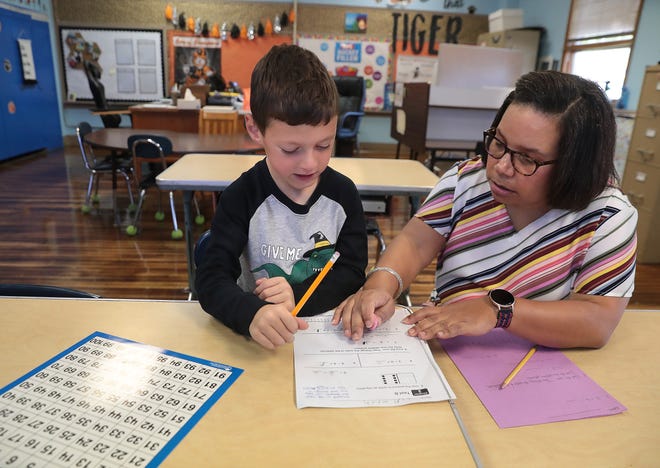 Clivette Stallworth, an intervention specialist at Whittier Elementary in Massillon, works with first grade student Cameron Frailly on a math lesson.