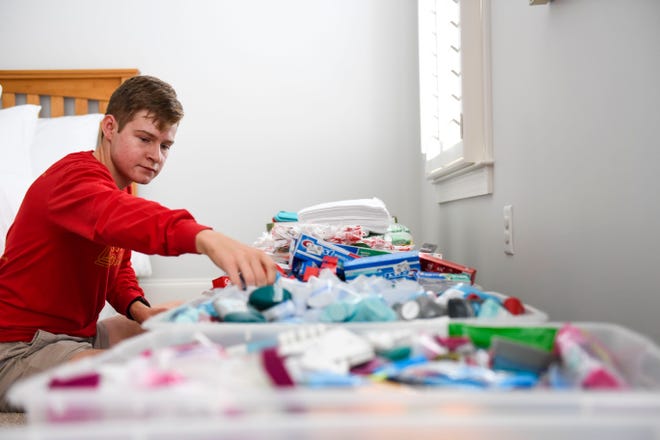 Connor Farrell, high school student and founder of Bright Lights Greenville, packages toiletries to provide to charities serving the homeless population at his home in Greenville on Wednesday, October 5, 2022. 