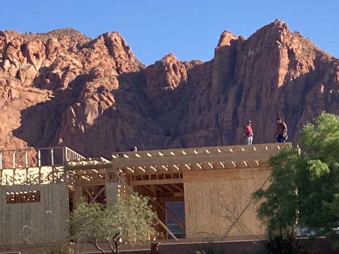 Construction crews work on a roof in front of Red Mountain in Ivins. New home prices fell slightly in September across the St. George metropolitan area, but housing demand remained at near-record levels, according to new data from Realtor.com.