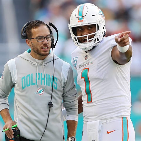 Dolphins coach Mike McDaniel speaks with quarterba
