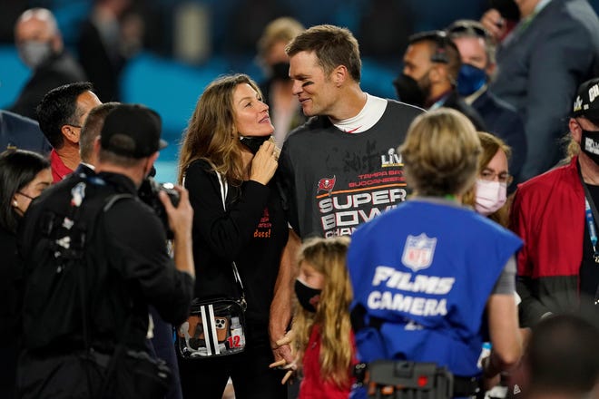 Tampa Bay Buccaneers quarterback Tom Brady walks with Gisele Bundchen on the field after the NFL Super Bowl 55 football game against the Kansas City Chiefs, Sunday, Feb. 7, 2021, in Tampa, Fla. The Tampa Bay Buccaneers defeated the Kansas City Chiefs 31-9.