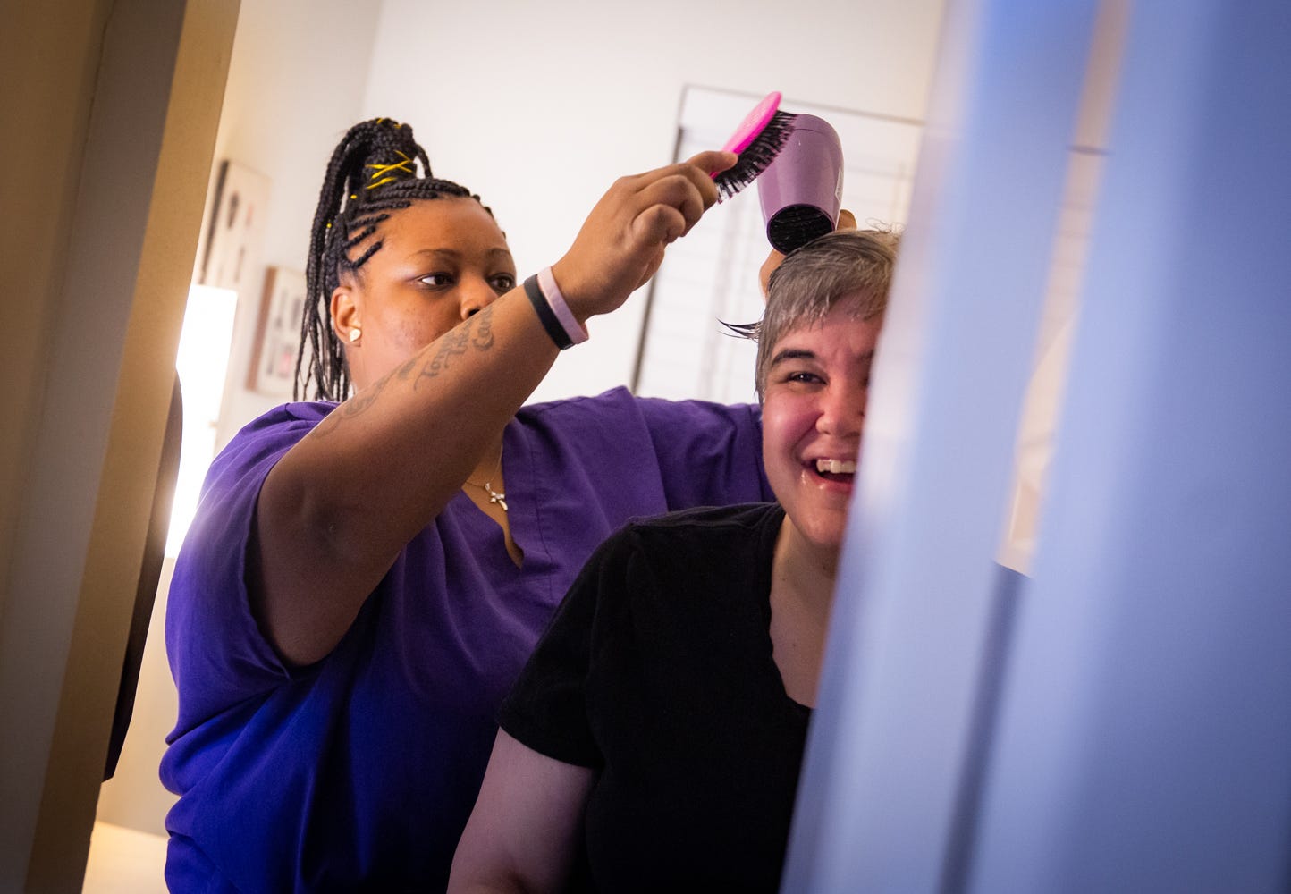 Tre'Asia Anderson helps client Cindy with her hair before breakfast at the Caregiver Inc. home in Tyler, where Anderson works. Cindy can’t quite say Anderson's name, so she calls her caregiver “Angel.”