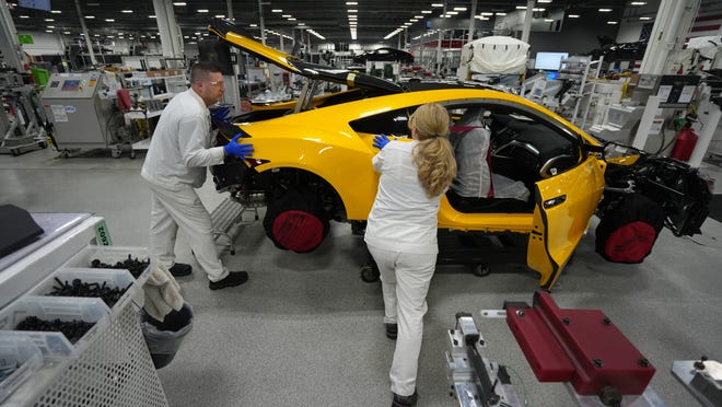 Ross Hackathorne (left) and Jenny Purtee install a rear fender on an Acura NSX as production winds down on the car at the Performance Manufacturing Center near Marysville.. Hackathorne has worked for Honda or Acura 26 years, Purtee for 25 years and both have been on the NSX production line since it started.