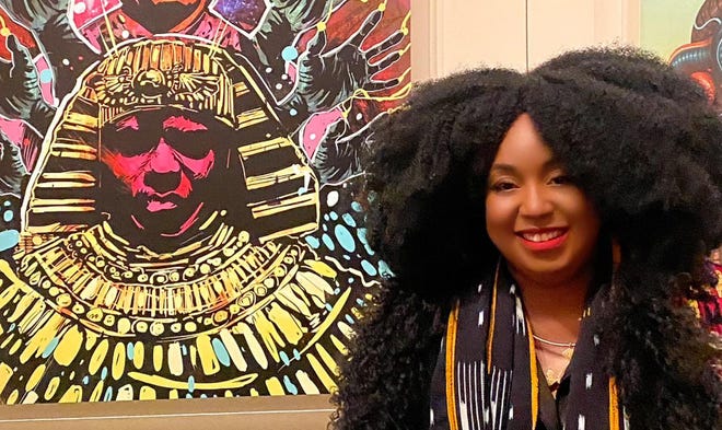 A portrait of musician Sun Ra watches as Sheree Renée Thomas attends the opening of a "Afrofuturism" exhibit at Carnegie Hall.