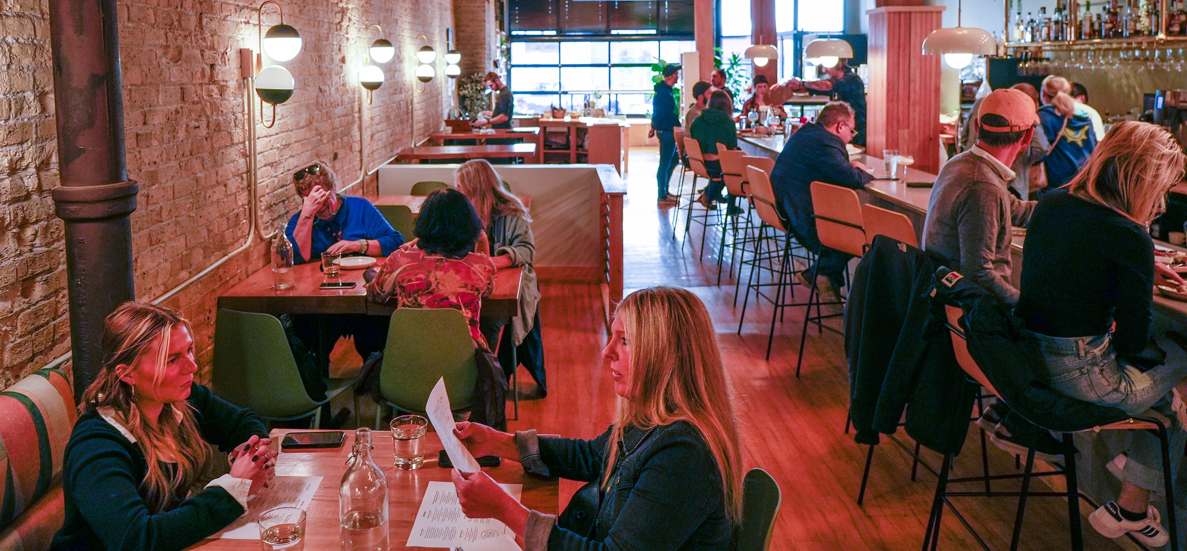 Cailin Mahoney, left front, and Susan Speidell look over the menu during a business dinner at Bavette la Boucherie's new location, 217 N. Broadway.