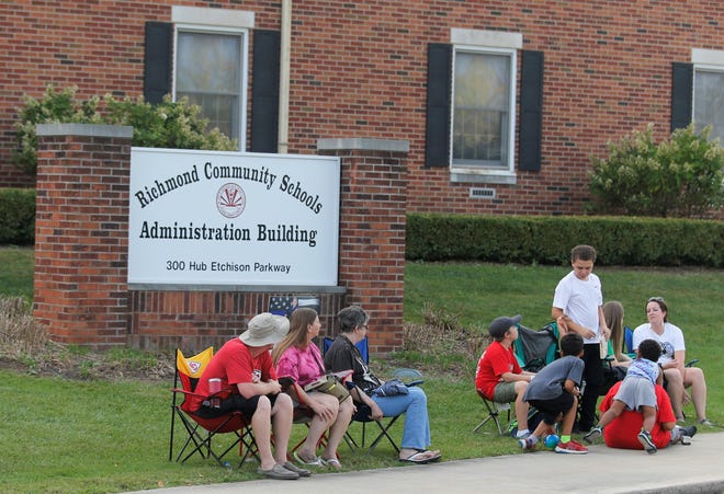 Residents sit in front of Richmond Community Schools' administrative offices sign during the Richmond Homecoming Parade Sept. 21, 2022.