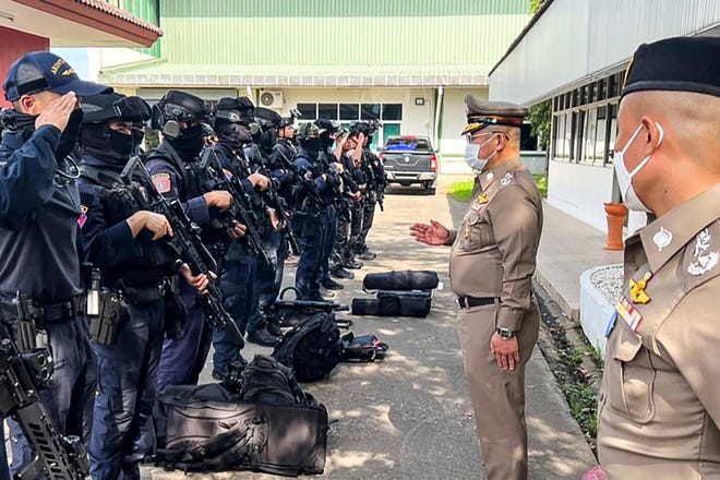 This handout picture taken and released by the Royal Thai Police on October 6, 2022 shows National Police Chief, Damrongsak Kittiprapat (2R), speaking with a police operation team in the northern Thai province of Nong Bua Lam Phu following an attack on a nursery.