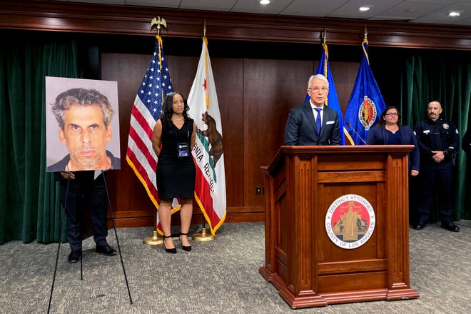 Los Angeles District Attorney George Gascón stands by a photo on display of TV producer Eric Weinberg during a news conference to announce sexual assault charges against Weinberg on Oct. 5, 2022.