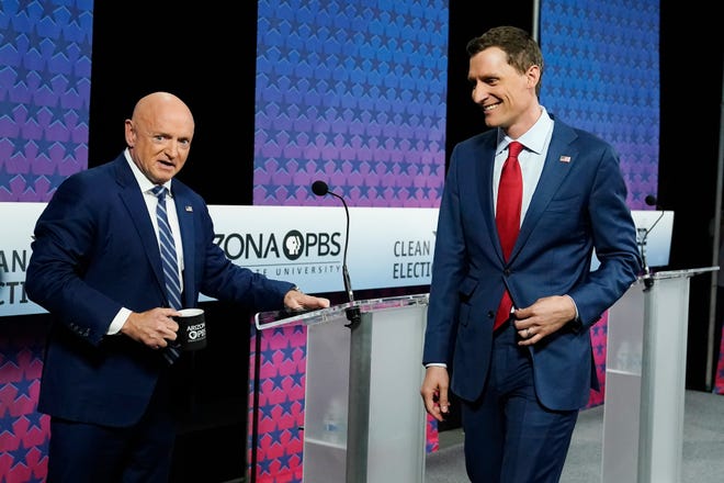 Arizona Democratic Sen. Mark Kelly, left, and his Republican challenger Blake Masters, right, arrive on stage prior to a televised debate in Phoenix, Thursday, Oct. 6, 2022.