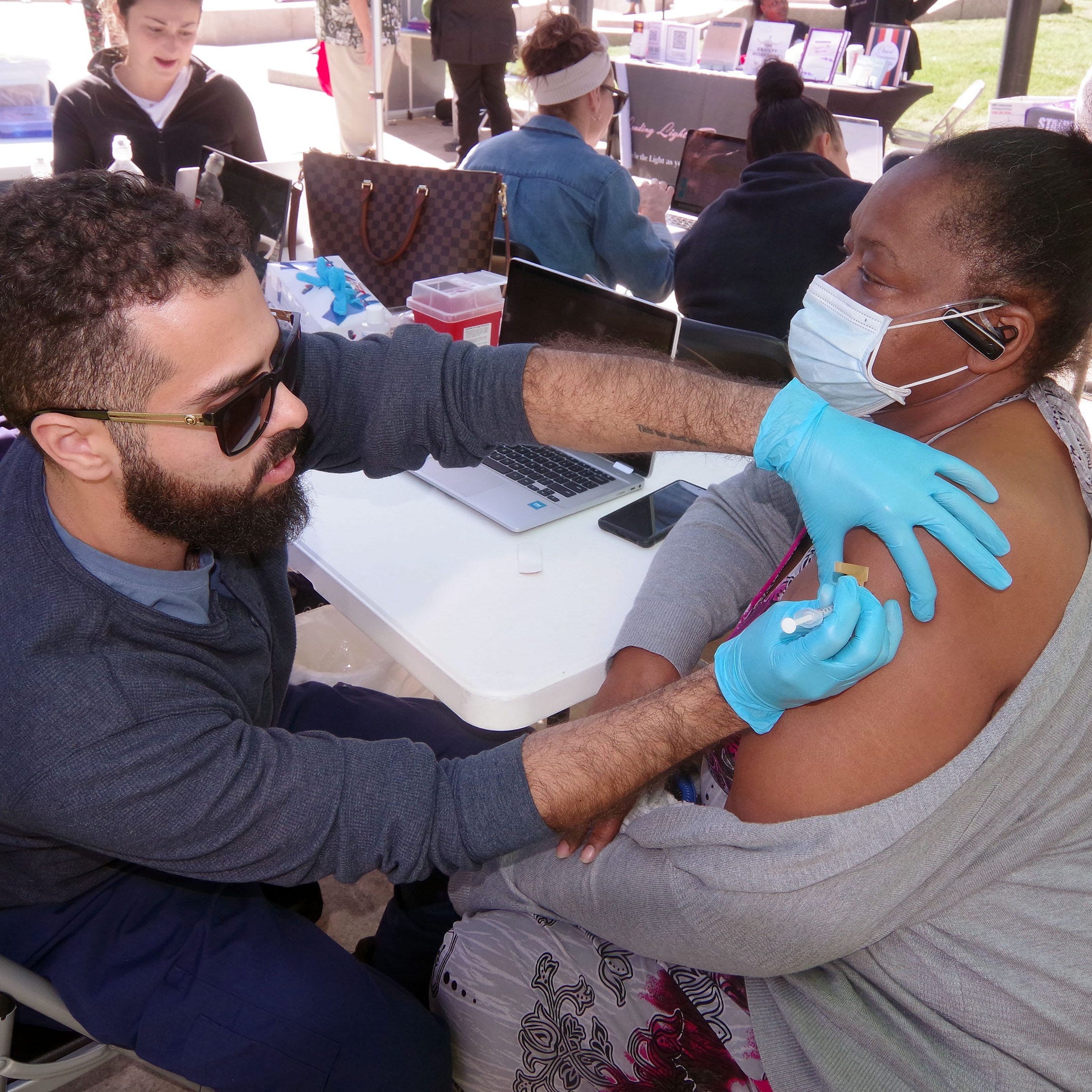 Forristean Gomes of Brockton, Massachusetts, gets a COVID-19 vaccine booster shot from a staff medical technician from East Coast Clinical Health Center. The vaccination came during 1st Responders Appreciation Day in Brockton on Sept. 27.