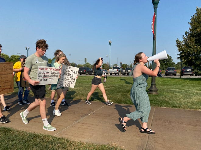 Lexi McKee-Hemenway leads a march across the University of South Dakota campus in protest of the recent Supreme Court decision that triggered an abortion ban in the state. About 50 students came with handmade signs, ready to march.