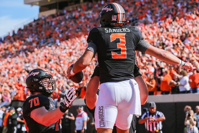 Oklahoma State's Spencer Sanders (3) celebrates after scoring a touchdown in the first quarter during a college football game between the Oklahoma State Cowboys and the Texas Tech Red Raiders at Boone Pickens Stadium in Stillwater, Okla., Saturday, Oct. 8, 2022.