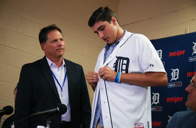 Scott Pleis watches Detroit Tigers first-round draft pick Alex Faedo try on a Tiger jersey Wednesday, July 5, 2017 at Comerica Park in Detroit.