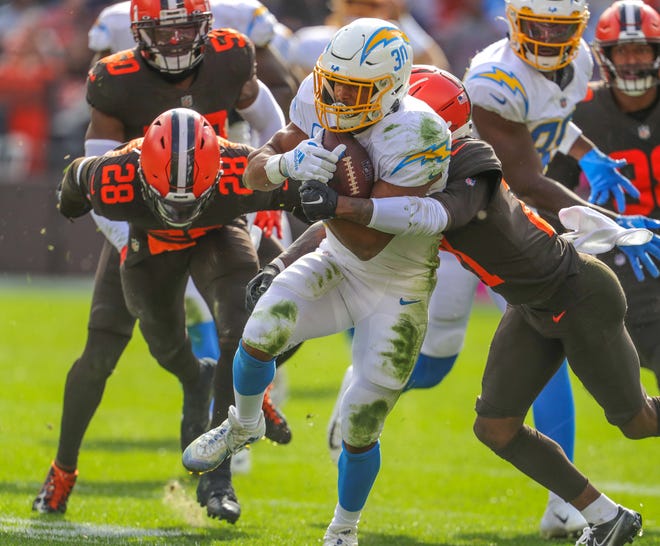 Browns defenders Denzel Ward, right, and Jeremiah Owusu-Koramoah chase down Chargers running back Austin Ekeler on Sunday, Oct. 9, 2022 in Cleveland.