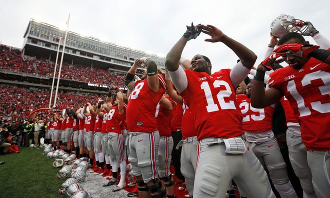 Ohio State Buckeyes quarterback Cardale Jones (12) sings Carmen Ohio with teammates following the NCAA football game against the Michigan Wolverines at Ohio Stadium on Nov. 29, 2014. The Buckeyes won 42-28. (Adam Cairns / The Columbus Dispatch)