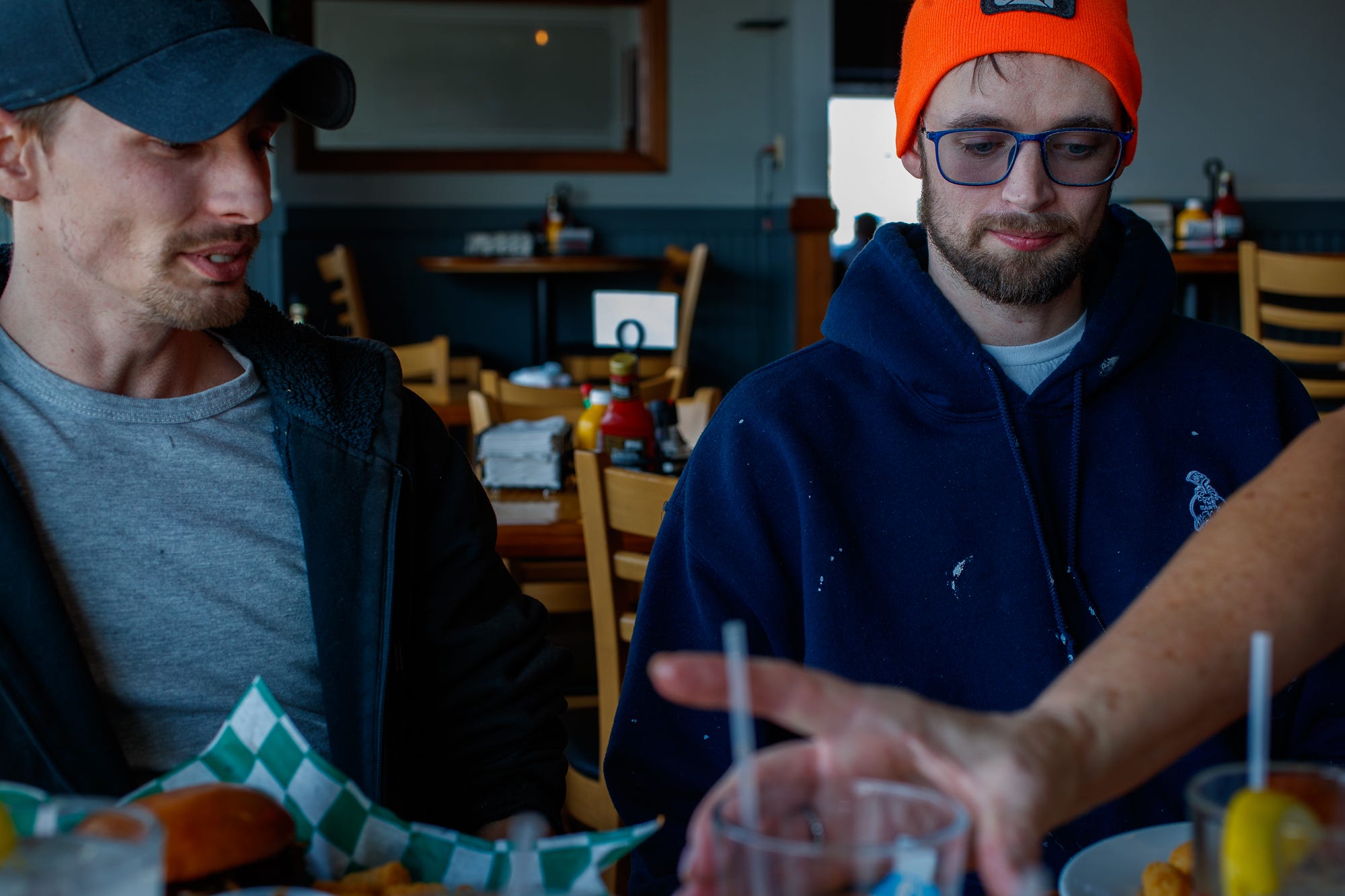 Tanner McAfee (left) and Kyle Ferguson eat at Sports Time Family Pub & Grill in Elkhart, Indiana, earlier this year. The friends were on break from a painting job after calling it quits in the RV industry.