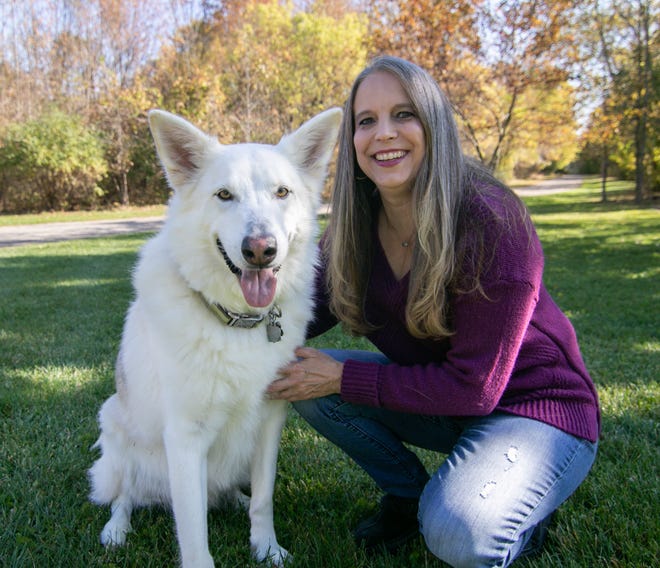 Sheila Hall-Gabriel poses on Monday, Oct. 10, 2022, with a white shepherd named Kai, one of a number of dogs she cares for at Gracie's Dog Haven in Oceola Township. Gracie's Dog Haven will be a vendor at the Growl-er Dogfest event in Brighton Oct. 16.
