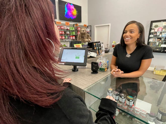 Cannabis activist and entrepreneur Evelyn LaChapelle, right, talks to an employee at a dispensary displaying her line of cannabis accessories in Oakland, Calif., on Oct. 7, 2022.