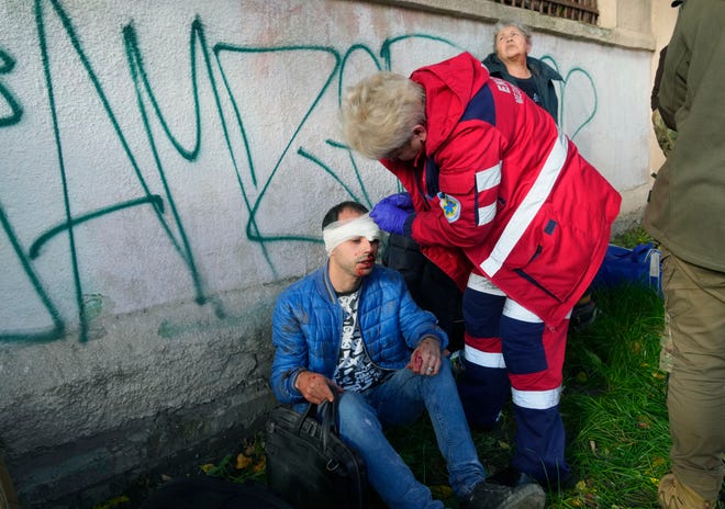 People receive medical treatment at the site of a Russian bombing in Kyiv, Ukraine, on Monday October 10, 2022. Two explosions rocked Kyiv early Monday after months of relative calm in the Ukrainian capital.