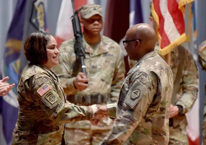 Command Sgt. Maj. Carlos Simmons contratulates incoming Command Sgt. Maj. Delia Quintero during a Feb. 6, 2020, change of responsibility ceremony at Fort Gordon, Georgia.