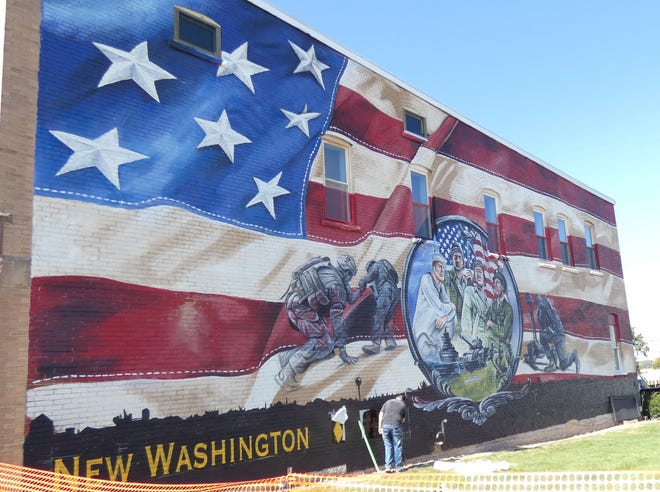 Dean Davis works on the mural for the planned New Washington Veterans Memorial Park.