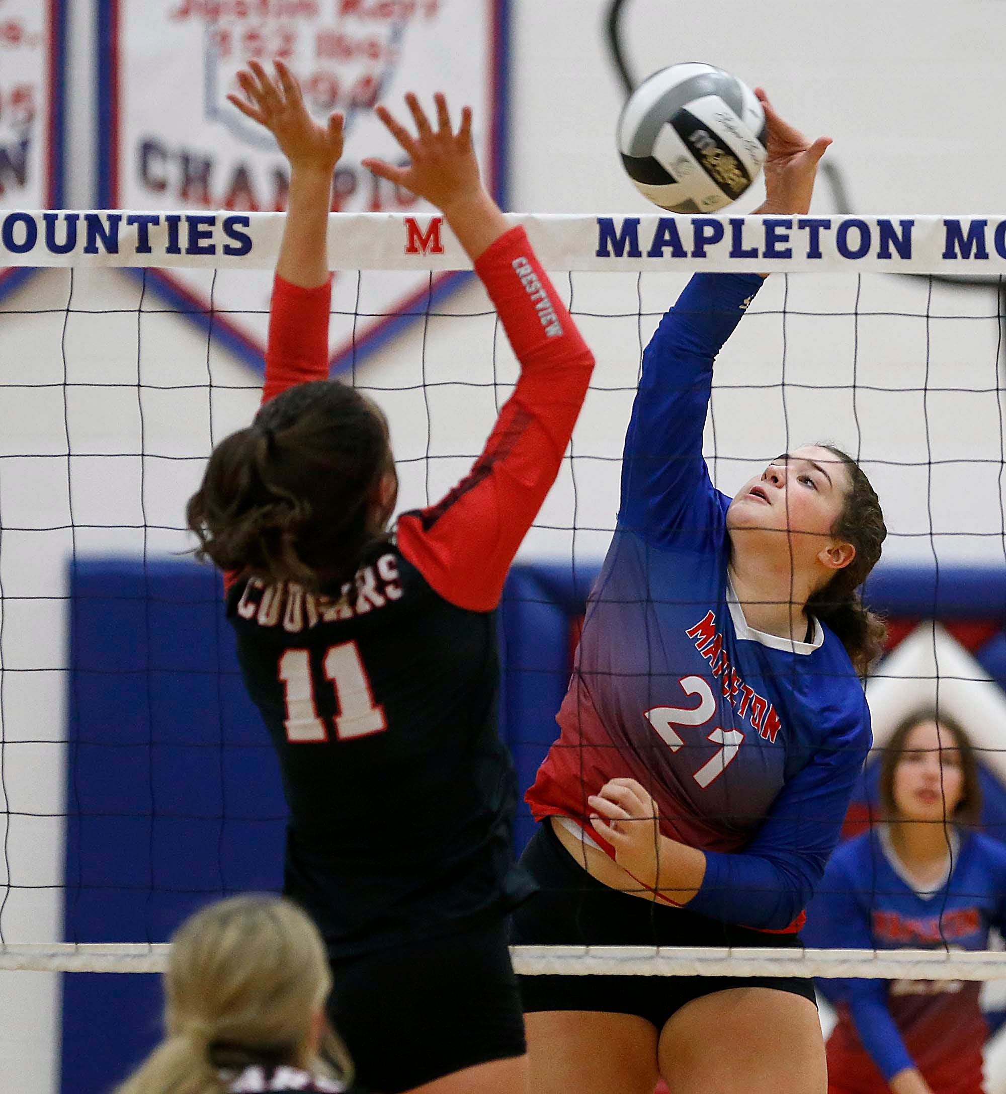 Mapleton High School's Bre McKean (21) plays a ball at the net against Crestview High School's Emily Weaver (11) during high school volleyball action at Mapleton High School Tuesday, Oct. 11, 2022. TOM E. PUSKAR/ASHLAND TIMES-GAZETTE