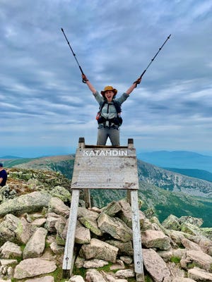 Annie Franklin celebrates her arrival at Mt. Katahdin, the final summit of the Appalachian Trail, completing the 2,200-mile journey from Georgia to Maine.