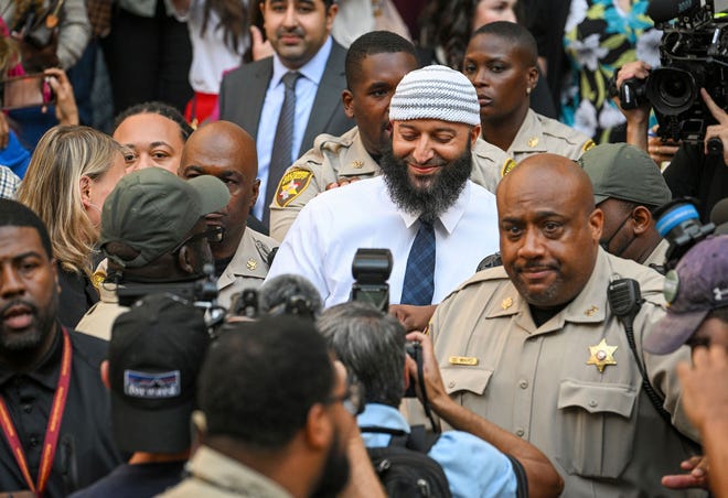 Adnan Syed, center, the man whose legal saga spawned the hit podcast "Serial," exits the Cummings Courthouse a free man after a Baltimore judge overturned his 1999 murder conviction, Monday, Sept, 19, 2022, in Baltimore. (Jerry Jackson/The Baltimore Sun via AP) ORG XMIT: MDBAE602