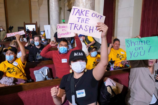 People hold signs and shout slogans before the starting the Los Angeles City Council meeting Tuesday, Oct. 11, 2022 in Los Angeles.