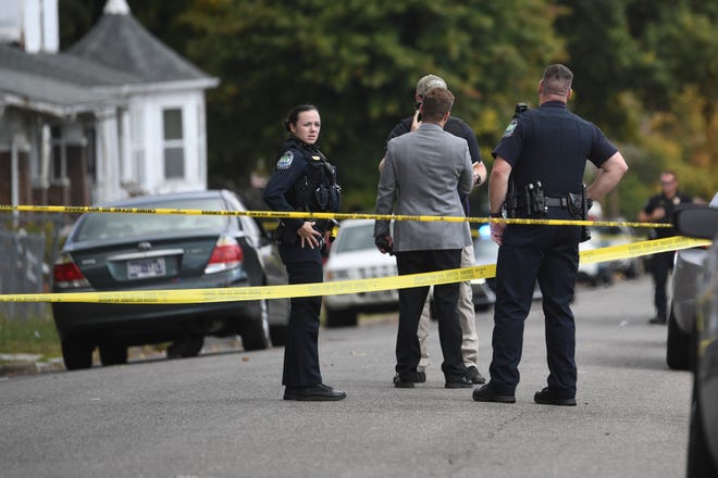 Law enforcement stands in Parkview Avenue behind crime scene tape near the location of a shooting in the Park City neighborhood, Thursday, Oct. 13, 2022.