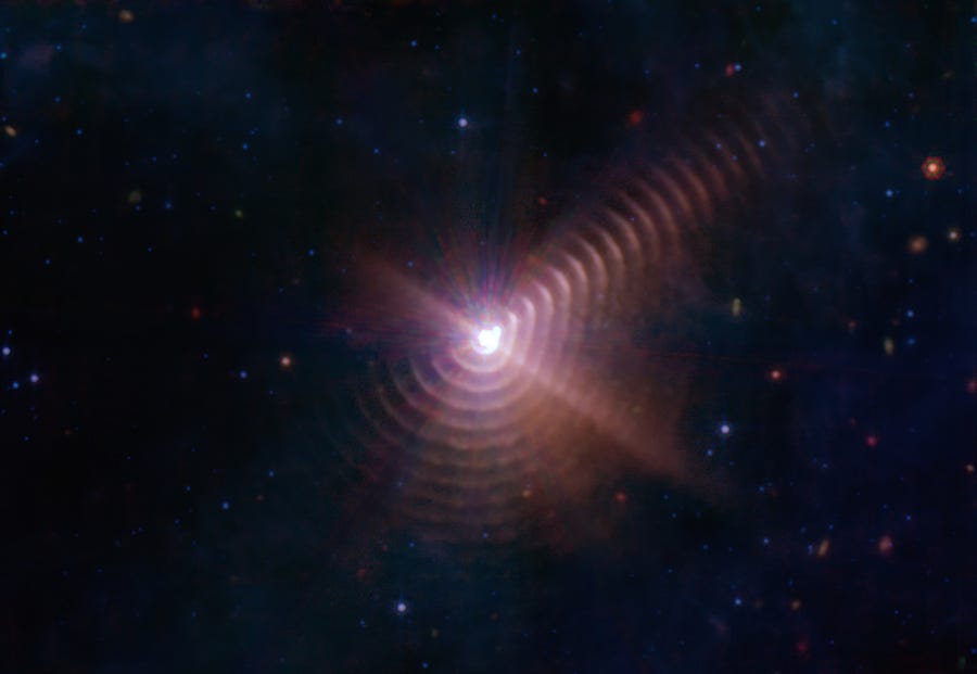 Shells of cosmic dust created by the interaction of binary stars appear like tree rings around Wolf-Rayet 140. The remarkable regularity of the shells' spacing indicates that they form like clockwork during the stars' eight-year orbit cycle, when the two members of the binary make their closest approach to one another.
