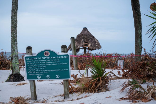 Sand is seen piled up under a welcome sign at Lowdermilk Park in Naples, FL., on Thursday, October 13, 2022. Almost two weeks after Hurricane Ian devastated parts of Lee and Collier counties, residents in the region are still recovering from the damage caused by the category 4 hurricane.