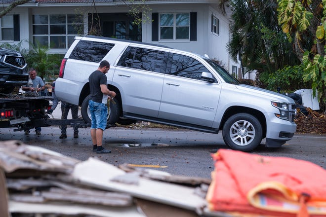 A tow driver prepares to tow a vehicle on Banyan Boulevard in Naples, FL., on Thursday, October 13, 2022. Almost two weeks after Hurricane Ian devastated parts of Lee and Collier counties, residents in the region are still recovering from the damage caused by the category 4 hurricane.
