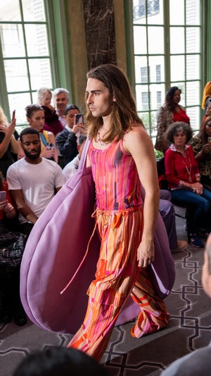 A catwalk model wears a Honeymouth bag at Paris Fashion Week.  Honeymouth is located in the former Crown & Goose home in downtown Knoxville, where Georgia Vogel worked as a bartender before bringing her leather business into space.