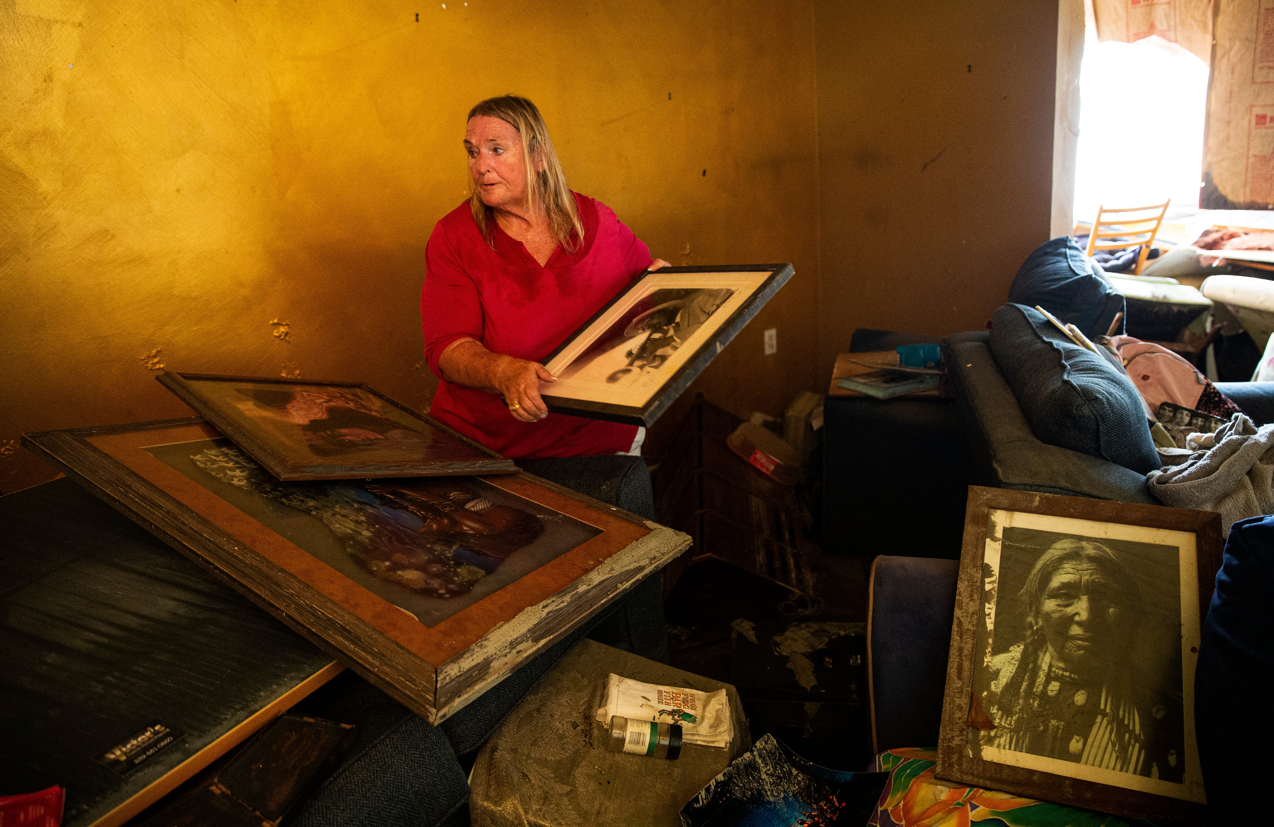 Judi Woods salvages pictures in her flooded Fort Myers Beach home on Oct. 11, 2022. Her neighborhood and home were heavily impacted by Hurricane Ian. Her home sustained significant damage.