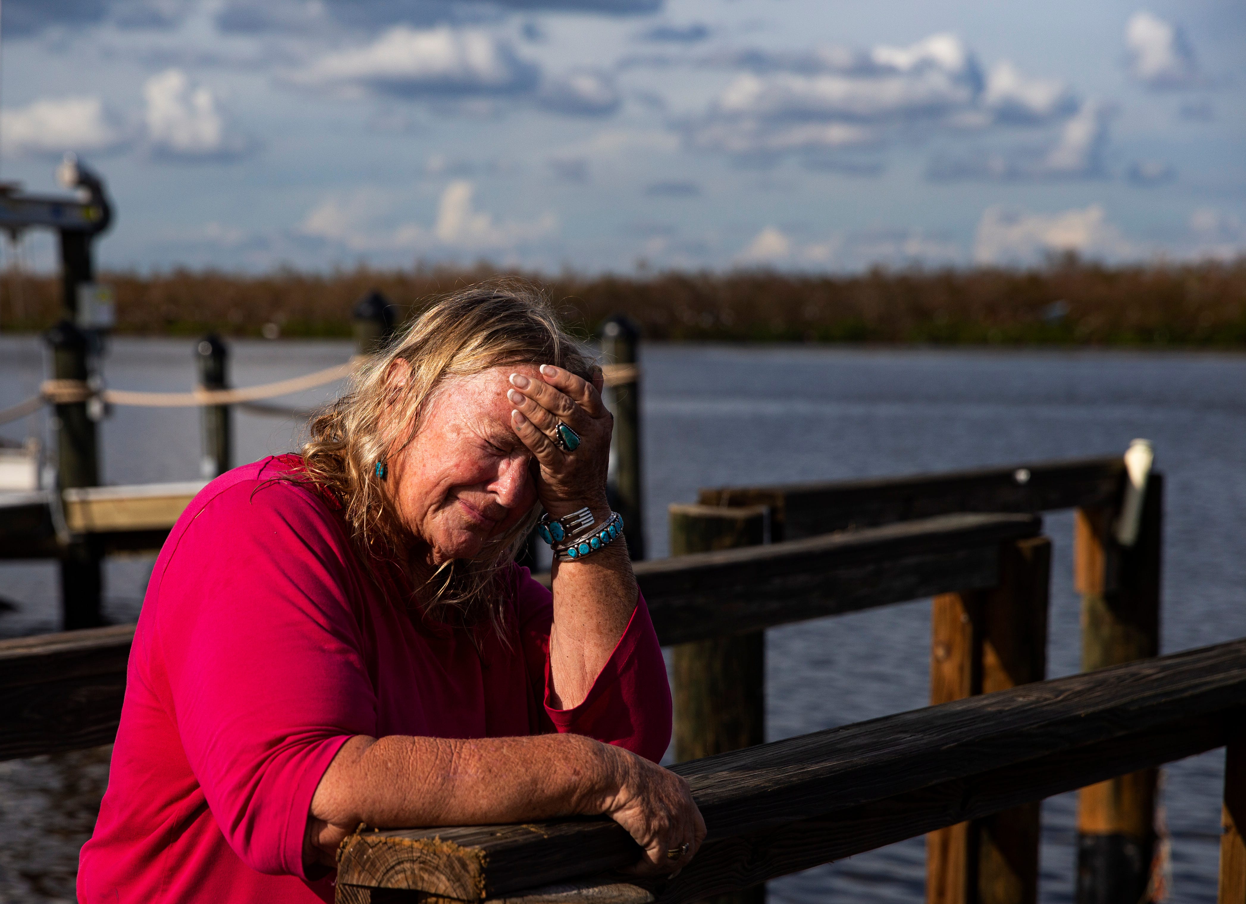 Standing on her neighborhood's dock, Judi Woods reacts after seeing her home on Oct. 11, 2022. Her neighborhood and home on Hibiscus Drive were heavily impacted by Hurricane Ian. Her home sustained significant damage.