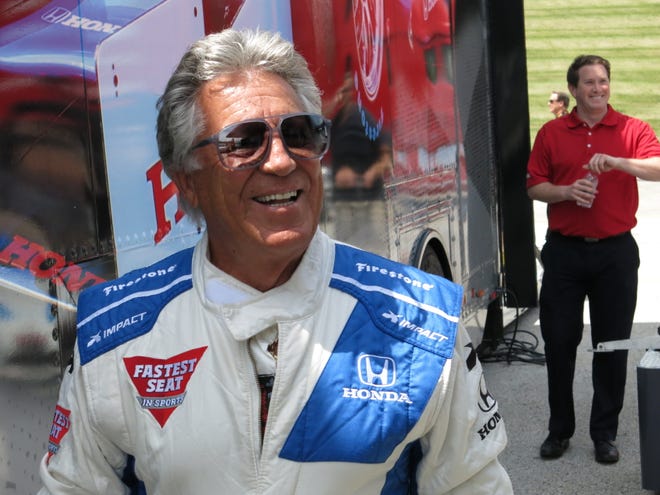 Retired IndyCar driver Mario Andretti walks out of a trailer at the Road America track in Elkhart Lake, Wis. on June 22, 2016.