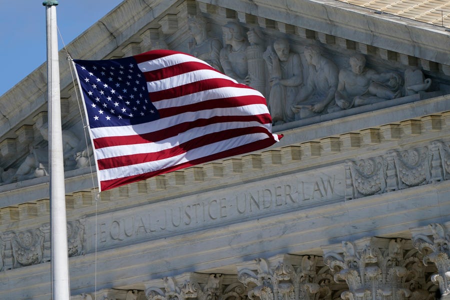 FILE - An American flag waves in front of the Supreme Court building, Nov. 2, 2020, on Capitol Hill in Washington.  A divided Supreme Court has rejected an appeal from a Black Texas death row inmate who argued he didn't get a fair trial because jurors who convicted him objected to interracial marriage. The court's three liberal justices dissented Tuesday from the court's order turning away the appeal from inmate Andre Thomas. He was sentenced to death for killing his estranged wife,   who was white, and two children.  (AP Photo/Patrick Semansky, File) ORG XMIT: WX203