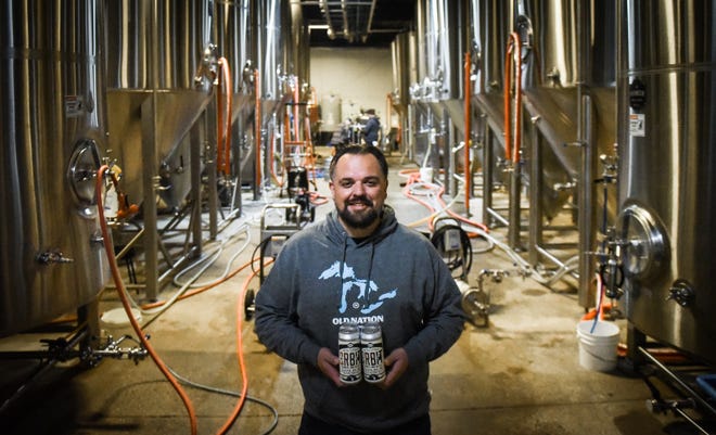 Travis Fritts, Old Nation Brewing Co. brewer and owner, in the Williamston brewery, Monday, Oct. 17, 2022, with the brewery's Low Orbit New England IPA.