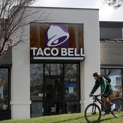 A customer rides his bike in front of a Taco Bell 
