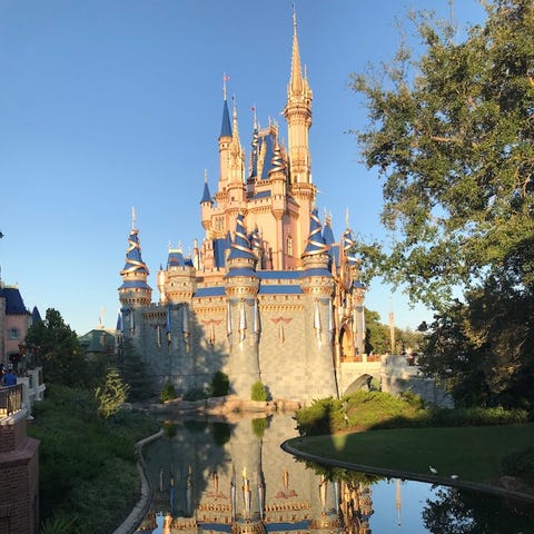 Cinderella Castle is reflected on the water at Wal