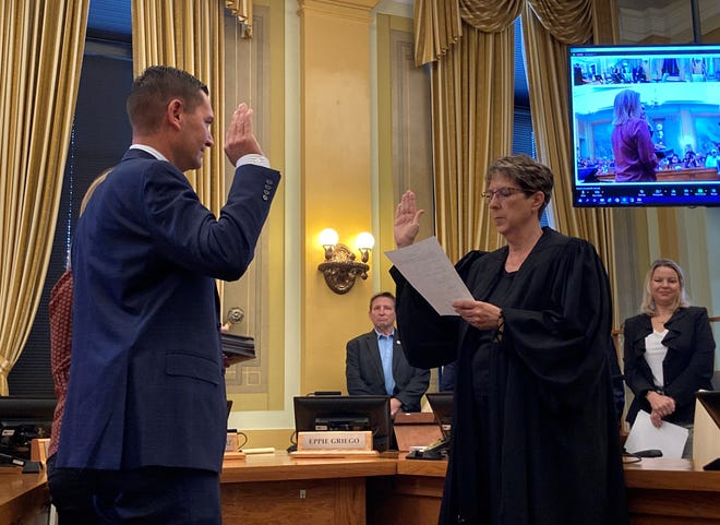 Chief District Judge Deborah Eyler swears in Sheriff David Lucero (left) at the county commissioners' chambers on Oct. 18, 2022, as Commissioner Chris Wiseman and County Attorney Cynthia Mitchell observe.