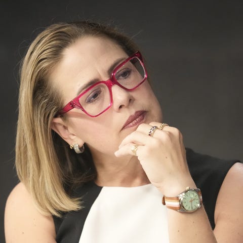 Sen. Kyrsten Sinema listens during a council of wa