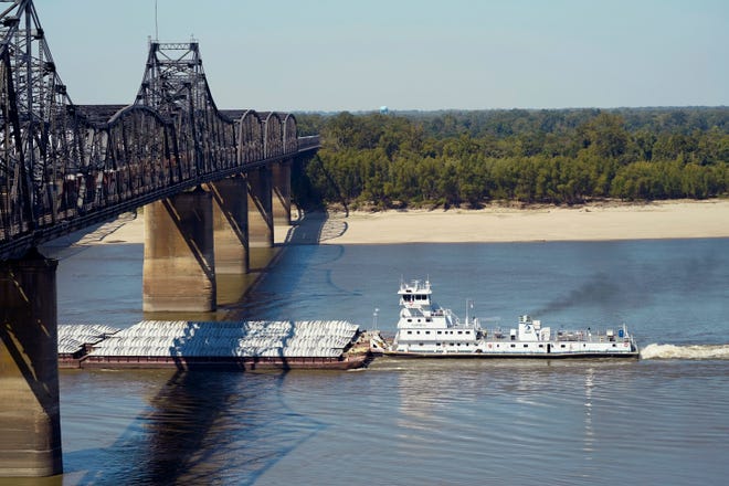 Low-water restrictions on the barge loads make for cautious navigation through the Mississippi River as evidenced by this tow passing under a Mississippi River bridge in Vicksburg, Tuesday, Oct. 11, 2022.